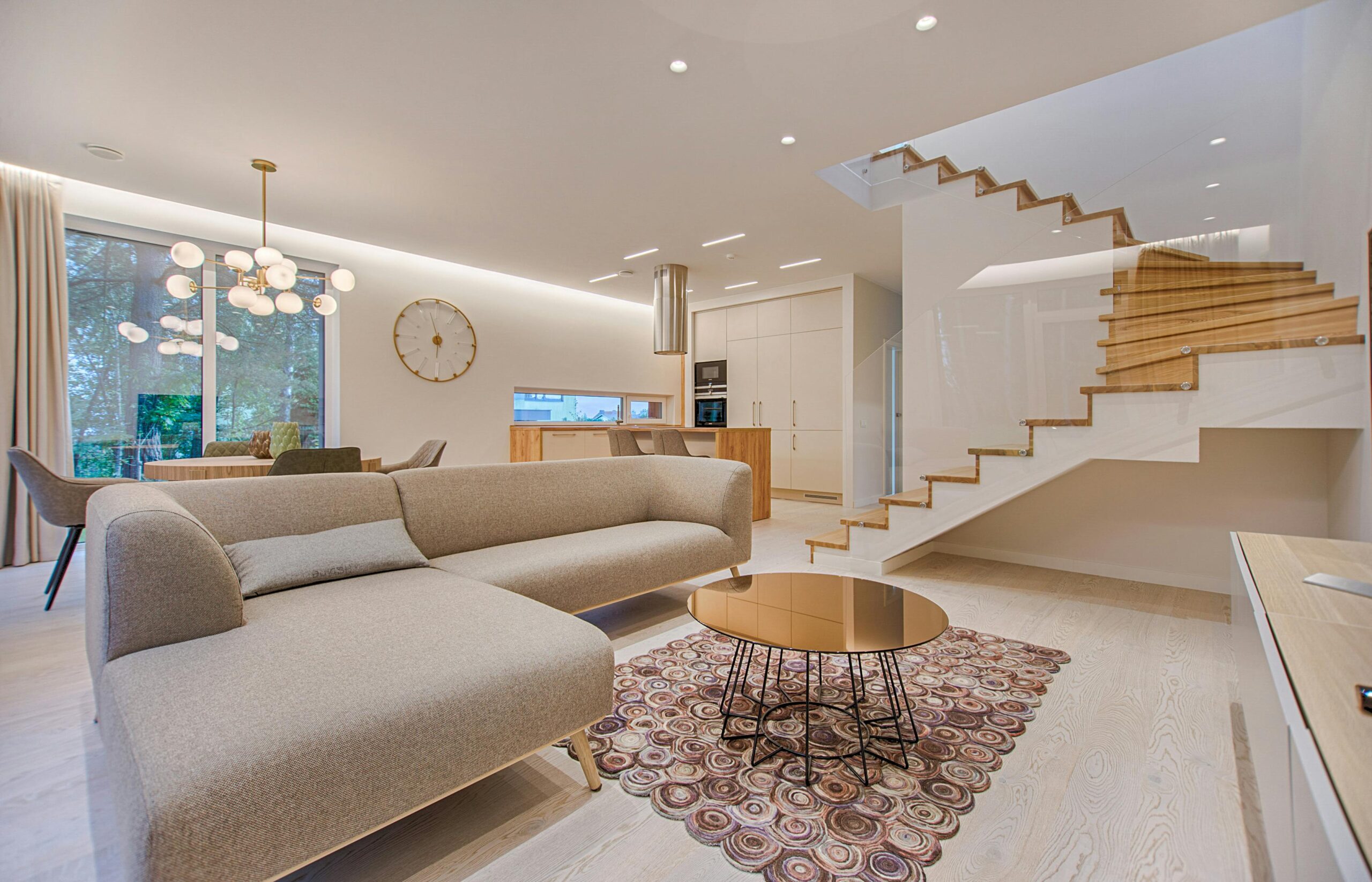 Service Contemporary living room with neutral tones, a sleek sofa, and elegant wooden staircase.